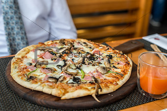 Pizza with mushrooms on  table in  restaurant