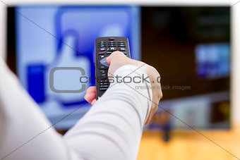 Closeup on woman hand holding remote control