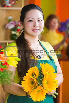 Pretty Woman in Flower Shop with Sunflowers