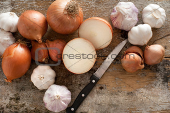 Whole and halved fresh uncooked garlic and onion