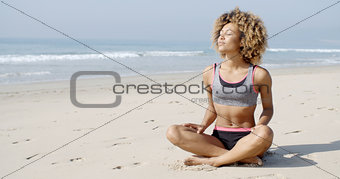 Woman Sitting On The Beach In Lotus Pose