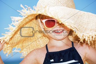 Portrait of happy girl wearing big straw hat