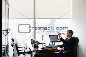Bored Business Man Throwing Paper Airplane In Office