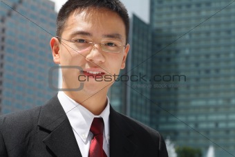 Young asian executive in front of office buildings
