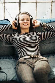 Happy young woman listening to the music through headphones