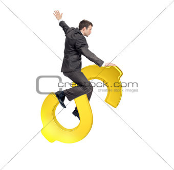 Businessman riding golden dollar sign