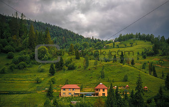 wooded Carpathians slopes with houses in center of the frame