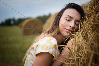 girl with eyes closed leaning against the hayloft
