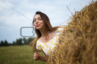 she coyly peeping from behind a haystack
