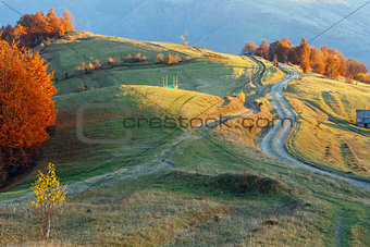 Rural road on autumn mountain slope.