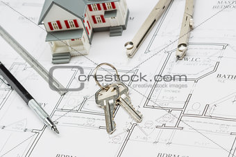 Home, Pencil, Ruler, Compass and Key Resting on House Plans