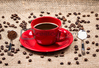 Coffee cup with coffee and sugar filled spoons