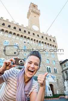 Woman tourist with photo camera showing thumbs up, Florence