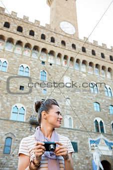 Woman tourist with photo camera looking aside. Florence, Italy