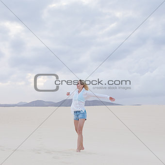Carefree woman enjoying freedom on beach.