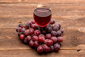 glass of wine or grape juice and fruit on wooden table