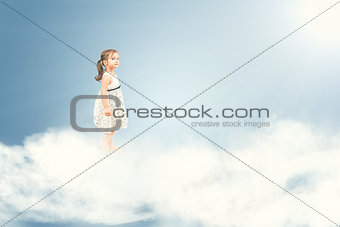 Cute little girl standing barefoot on clouds