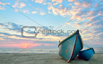 sunrise over an  wooden fishing boats