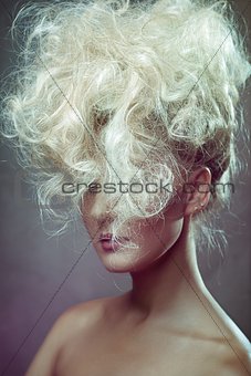 Pretty woman with curly hair on gray background