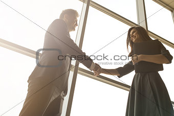 Business men and women shaking hands with a smile