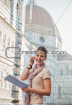 Happy woman tourist with map having audio walking tour, Florence