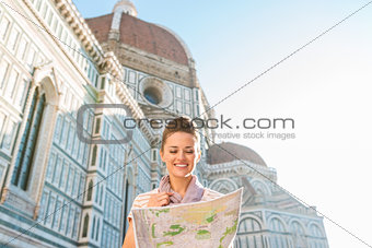 Happy woman tourist looking at map while standing near Duomo
