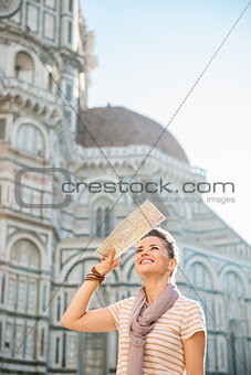 Smiling woman tourist with map sightseeing in Florence, Italy