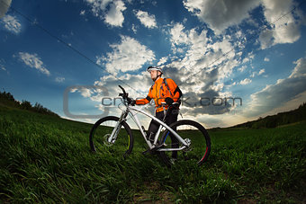 Cyclist with  the Bike on meadow