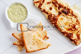 Omelette with toastes and green sauce