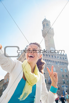 Woman showing victory and taking selfie near Palazzo Vecchio