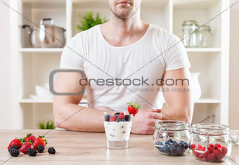 Closeup on man with delicious yoghurt with fresh berries