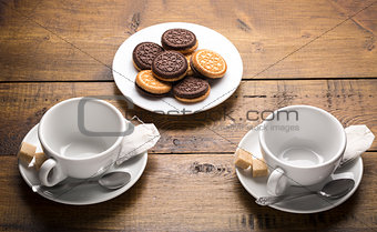 Set of two ceramic tea mugs with sachet and plates of cookies. Preparation for brewing tea.