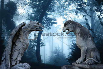 Ancient eagle and lion statues in misty forest