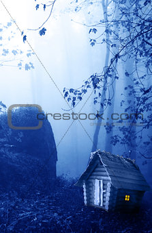 Wooden house and mysterious landscape of foggy forest 