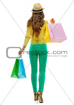 Seen from behind woman with shopping bags making step