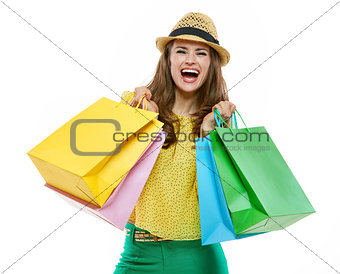 Woman in hat and bright clothes with shopping bags rejoicing
