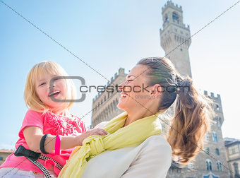 Portrait of smiling mother and daughter near Palazzo Vecchio