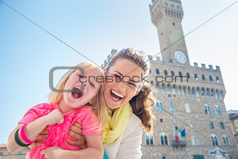 Portrait of cheerful mother and child near Palazzo Vecchio