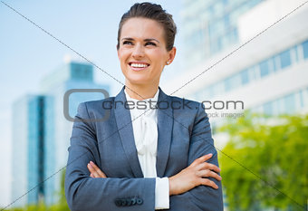 Smiling business woman in office district looking into distance