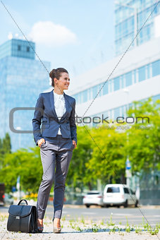 Business woman with briefcase standing in modern office district