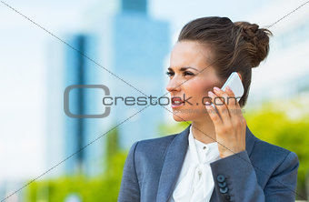 Business woman in modern office district talking smartphone