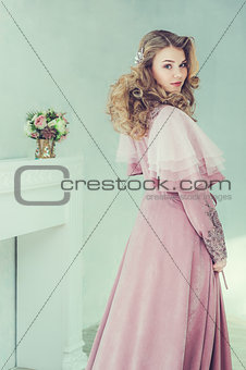 Portrait of beautiful blonde woman with curly hairstyle. Studio shoot.