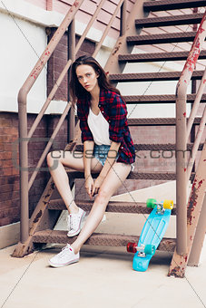 Hipster girl on metal stairs.