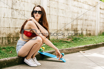 Cute hipster girl in bikini with skateboard.