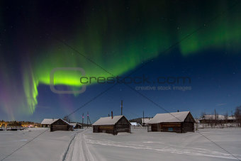 Village house in the lights of moon and Aurora borealis. Northern Karelia. Russia.