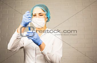 science, chemistry, biology, medicine and people concept - close up of young female scientist holding test tube  making research in clinical laboratory.