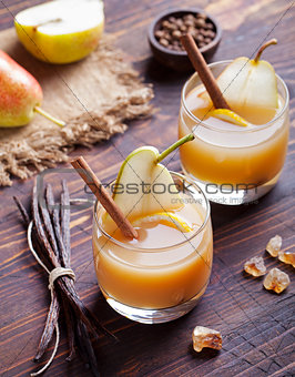 Pear mulled cider with vanilla and cinnamon sticks on a wooden background