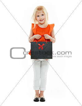 Blond girl in orange shirt with shopping bag on white background