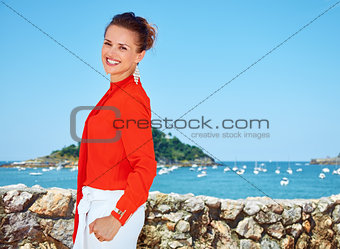 Happy woman in front of scenery overlooking lagoon with yachts