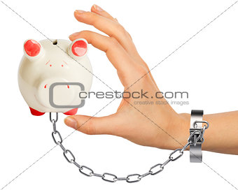 Chained hand holding piggy bank